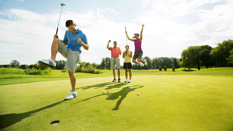 Golfers celebrating a holed putt on the green